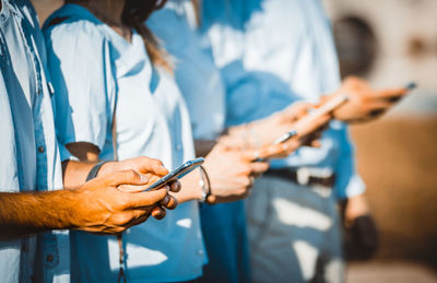 Midsection of man holding mobile phone