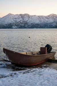 Boat moored in lake against sky