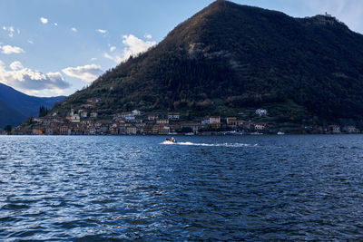 Scenic view of lake by mountains against sky