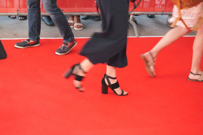 Low section of people walking at red carpet event