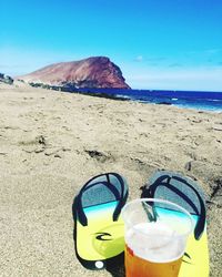 Drinking water on beach against blue sky