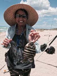 Portrait of smiling young woman standing on beach