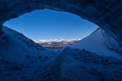 Scenic view of snowcapped mountains against blue sky