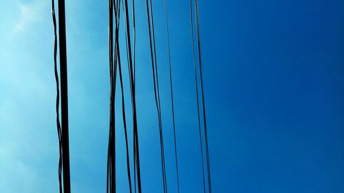 Low angle view of cables against clear blue sky