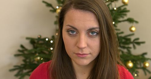 Portrait of young woman with christmas tree