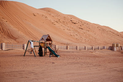 People playing on outdoor play equipment in desert