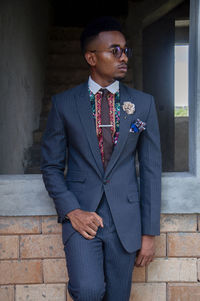 Young man standing against wall