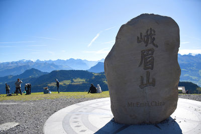 Information sign on mountain against sky