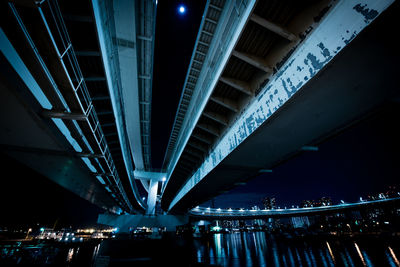 Illuminated bridge in city against sky at night