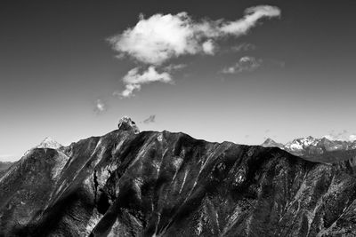 Low angle view of bird perching on mountain against sky