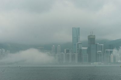 Modern buildings in city during foggy weather