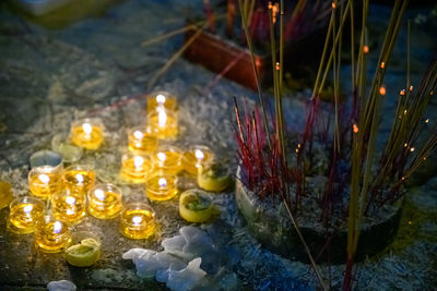 High angle view of burning candles in temple