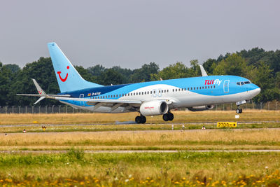 Side view of airplane on runway against clear sky