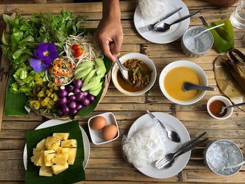 Cropped hand having food at table in restaurant