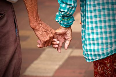 Midsection of senior couple holding hands