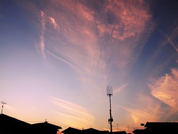 Low angle view of silhouette cranes against sky during sunset