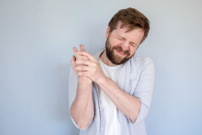 Young man standing against white background