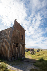 House in ghost town on field against sky