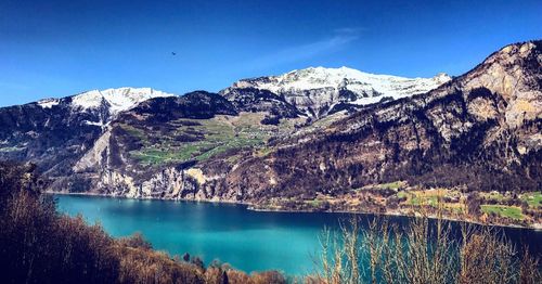 Scenic view of lake and mountains against clear sky