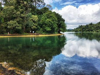 Scenic view of lake by trees against sky