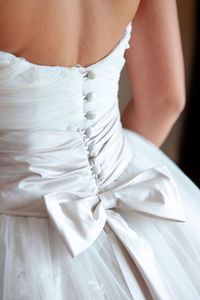 Midsection of bride wearing wedding dress