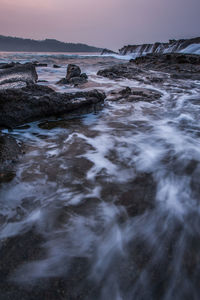 Surface level of rocks in sea against sky