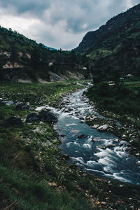 Scenic view of river amidst mountains against sky