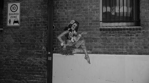 Reflection of woman on window of brick wall