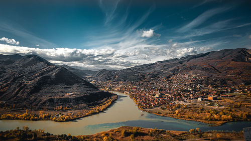 Aerial view of lake by mountains against sky