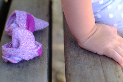 Low section of child on pink wood