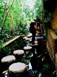 Woman standing on tree trunk