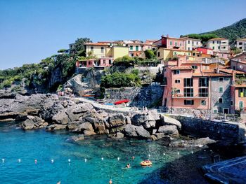 Buildings by rocks against blue sky