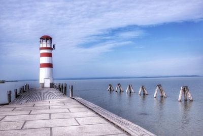 Lighthouse on sea against sky