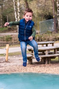 Portrait of happy boy on slide at playground