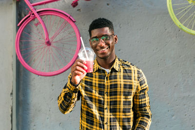 Portrait of young man standing against wall