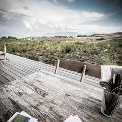 Empty chairs and tables against sky