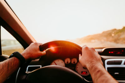 Cropped hand of man driving car