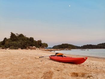 Boat moored on beach against sky