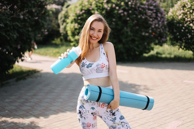 Happy fun healthy athletic girl in sportswear training and exercising in the park in nature outdoors