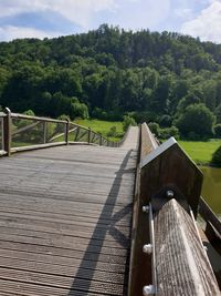 View of wooden footbridge against trees