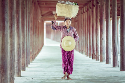 Full length of woman standing against wall