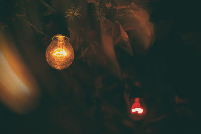 Close-up of illuminated lighting equipment hanging at night