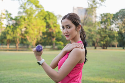 Portrait of young woman standing on field