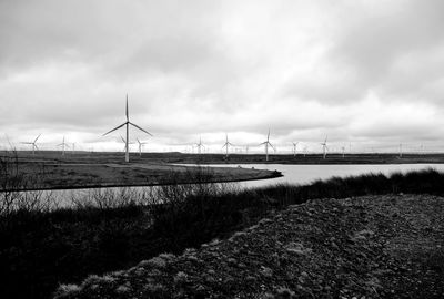 Scenic view of reservoir and field against sky