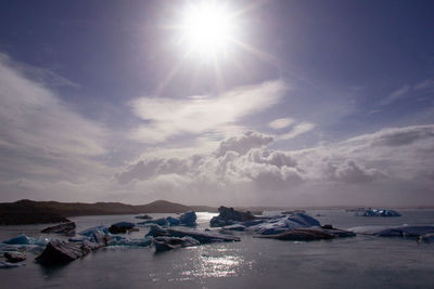 Scenic view of sea against bright sun