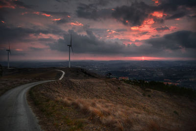 Road by landscape against sky during sunset