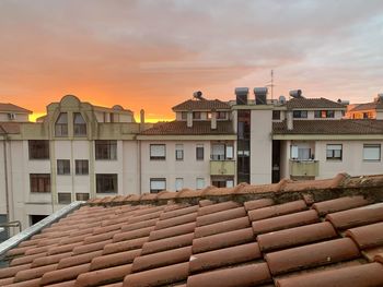 Residential buildings against sky during sunset