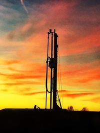 Silhouette of crane against sky during sunset