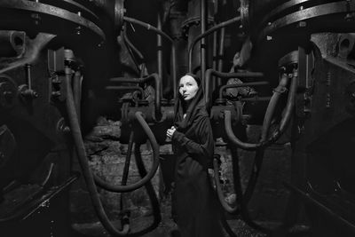 Woman standing against machinery