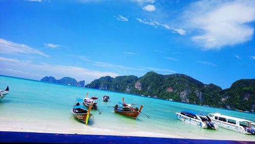 People on boats in sea against blue sky